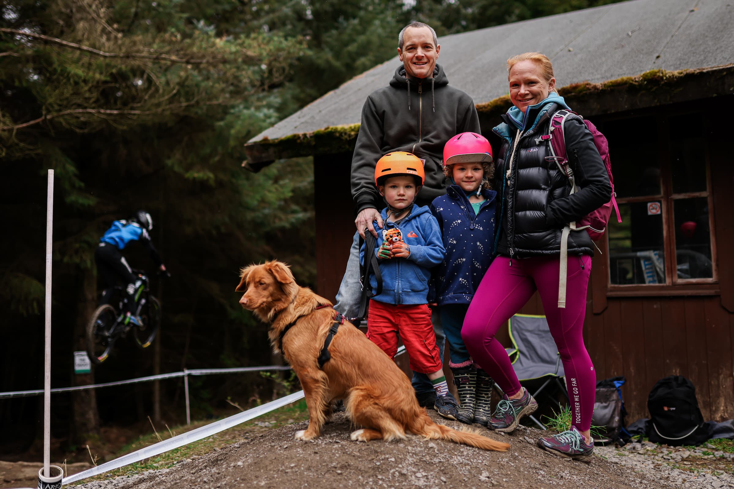 A family with their dog spectating at a cycling event