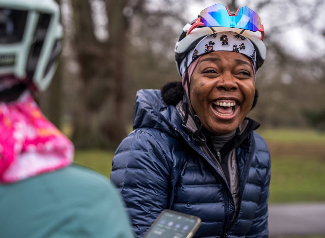 A cyclist laughing with her ride group