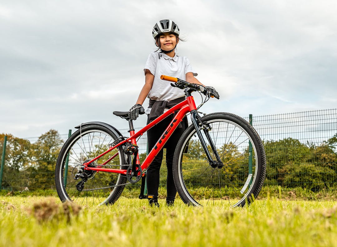 A girl holding a bike at a coaching session